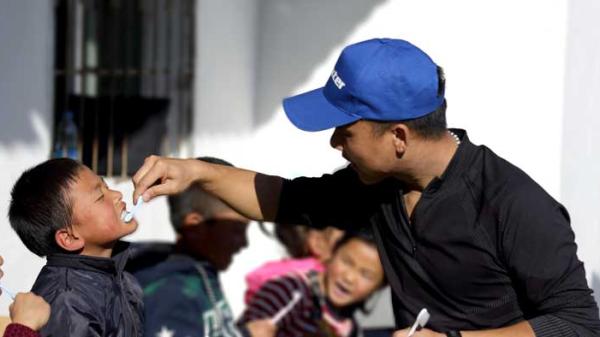 Baxter employee teach children to brush their teeth properly